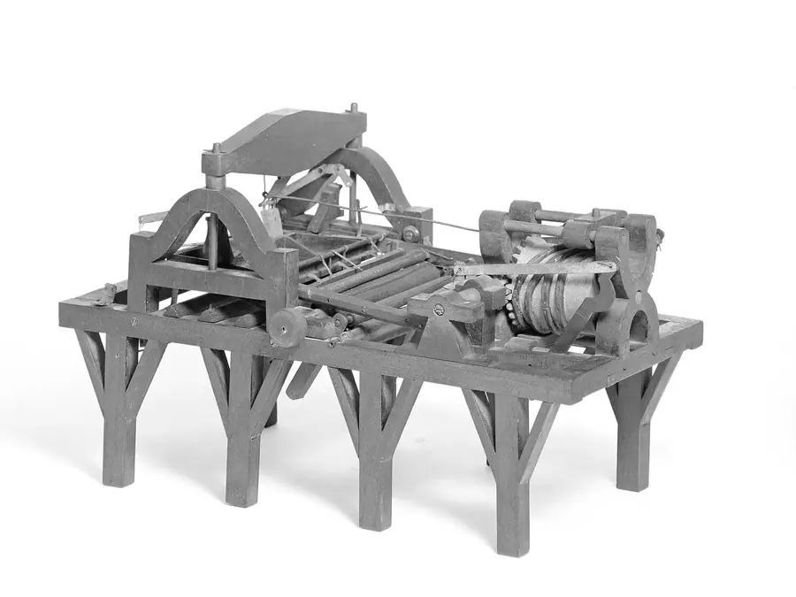 A scale model of a bed-and-platen press standing on six legs