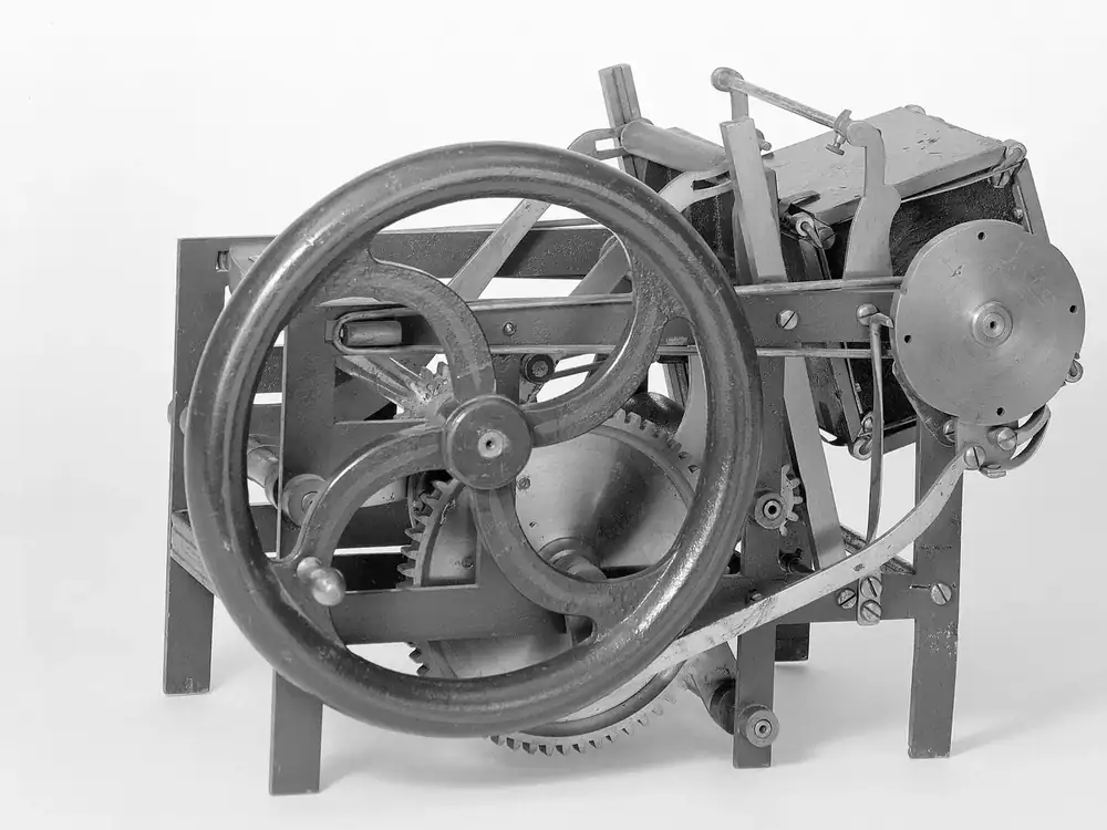A scale model of a self-inking platen press, its flywheel to the left