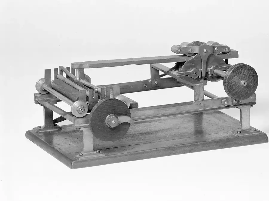 A scale model of hand inking rollers on a wooden base