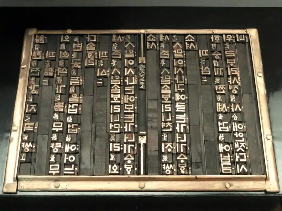 Cast type set in rows inside a metal-bound tray