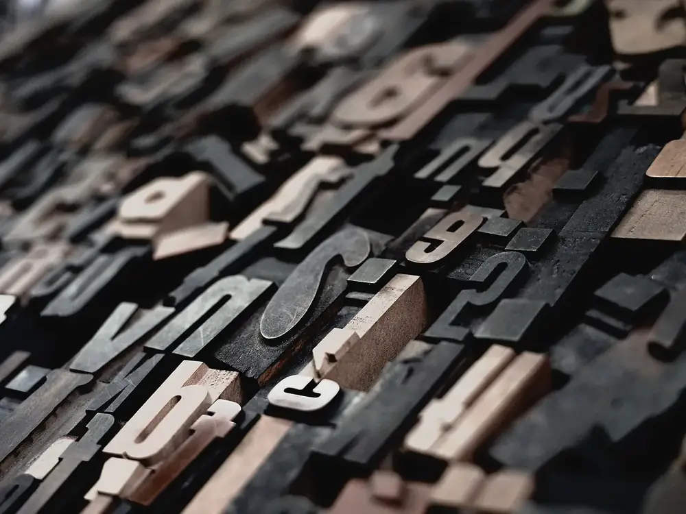 Loose wood type letters heaped on a bench, seen close